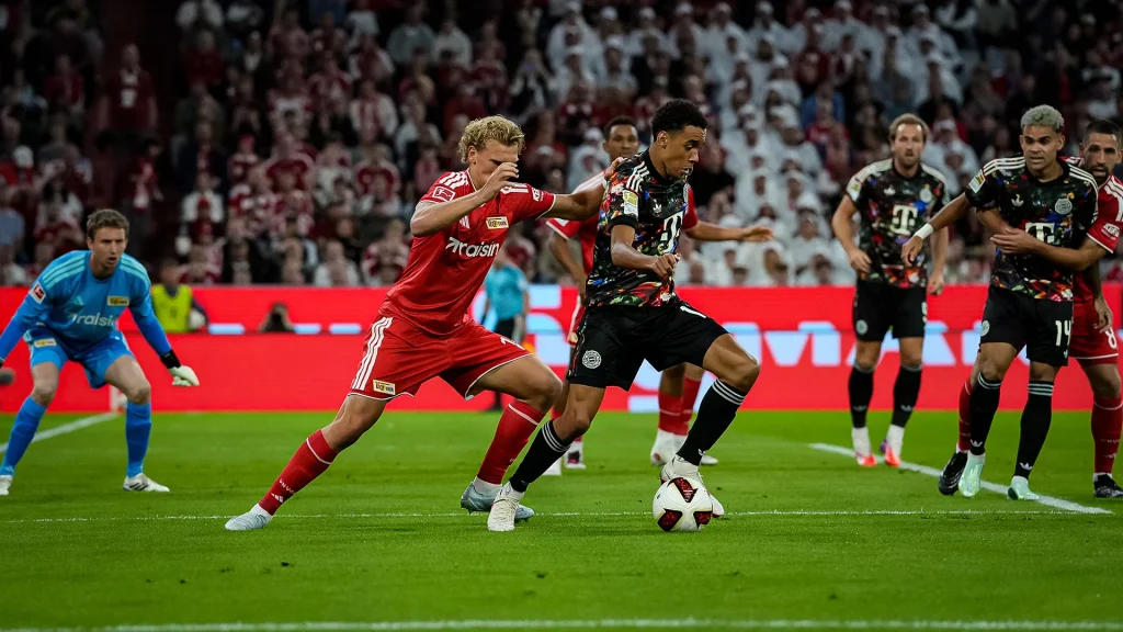 Jamal Musiala im Zweikampf mit Ball am Fuß während des Bundesligaspiels zwischen dem FC Bayern und Union Berlin