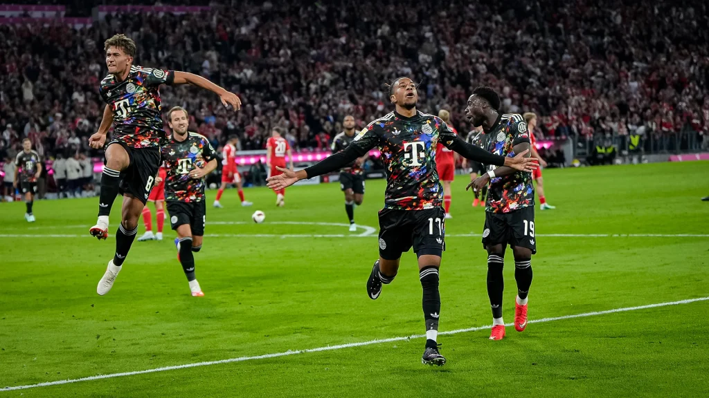 Michael Olise, Tom Bischof und Alphonso Davies stürmen auf die Kurve zu während des Bundesligaspiels zwischen dem FC Bayern und Union Berlin