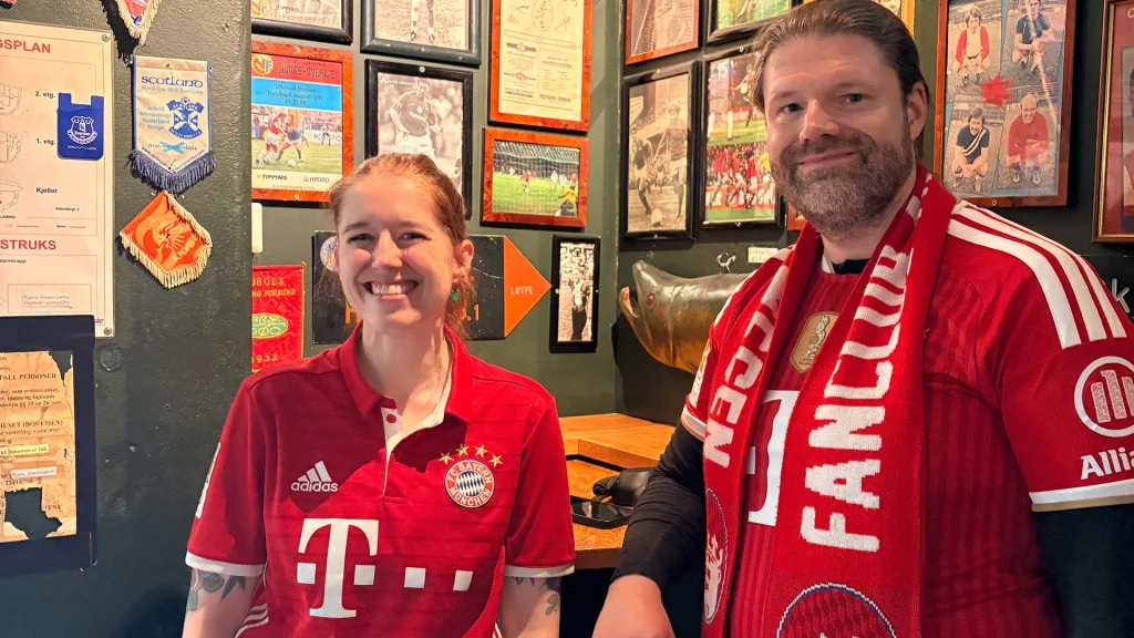 Fans in red Bayern shirts posing for a photo.