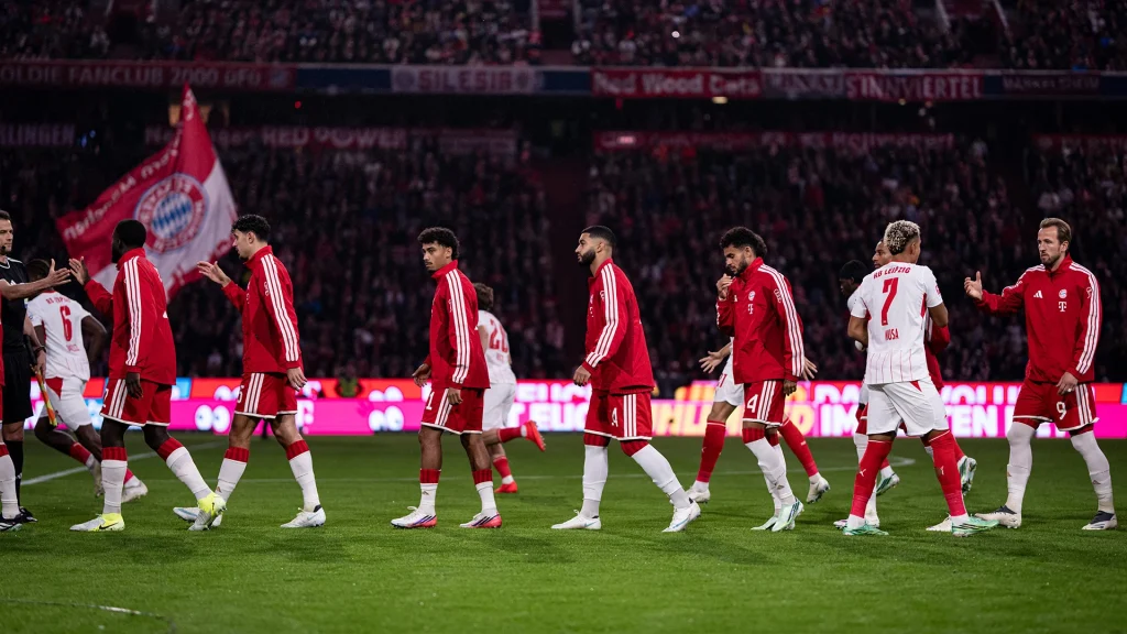 Die Teams klatschen sich vor Anpfiff ab im Bundesliga-Topspiel zwischen dem FC Bayern und RB Leipzig.