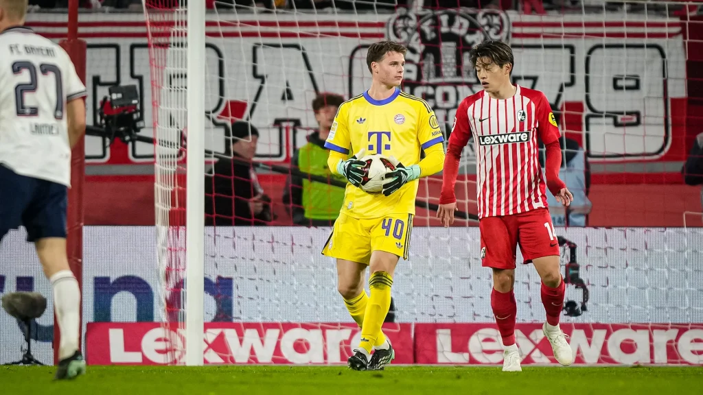 Jonas Urbig mit Ball in der Hand während des Auswärtsspiels des FC Bayern in der Bundesliga beim SC Freiburg