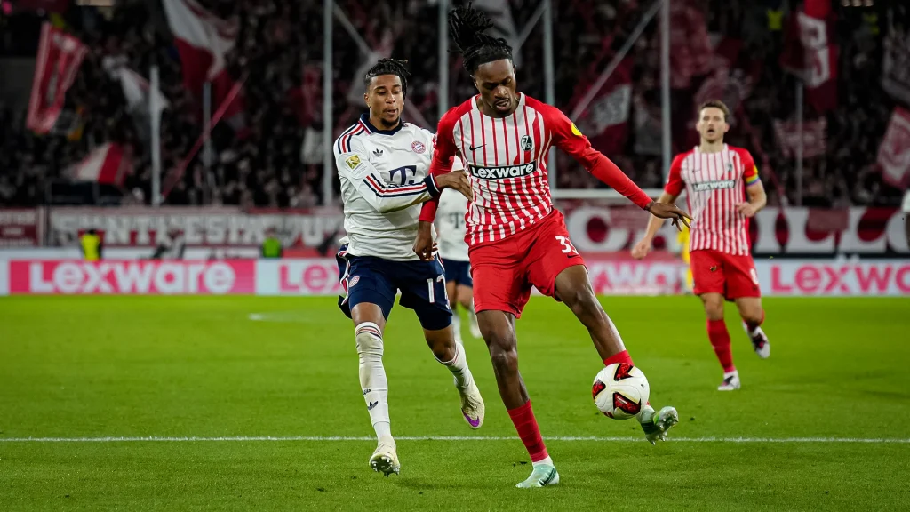 Michael Olise im Zweikampf während des Auswärtsspiels des FC Bayern in der Bundesliga beim SC Freiburg